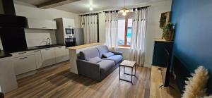 un salon avec un canapé et une cuisine dans l'établissement Charmant appartement au cœur du centre historique, à Beaujeu