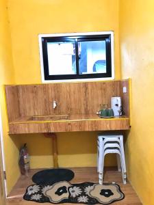 Habitación pequeña con lavabo y ventana en Three Sister's Inn, en Siquijor