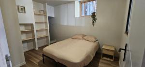 une petite chambre avec un lit et une fenêtre dans l'établissement Charmant appartement au cœur du centre historique, à Beaujeu