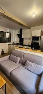 - un salon avec un canapé en face d'une cuisine dans l'établissement Charmant appartement au cœur du centre historique, à Beaujeu