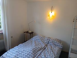 a bedroom with a bed and a light on the wall at Gästewohnung im Schlosshof in Riedlingen
