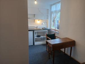 a small kitchen with a table and a desk and a table and a tableearcher at Gästewohnung im Schlosshof in Riedlingen