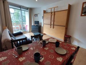 a living room with a table with a red table cloth at Studio 4 pers avec balcon, au pied des pistes, proche ESF et remontées mécaniques - FR-1-516-193 in Les Deux Alpes +7 photos
