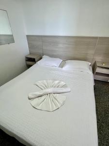 Flat Beira Mar - Fortaleza في فورتاليزا: سرير ابيض عليه منديل