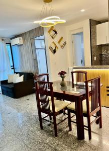 Flat Beira Mar - Fortaleza في فورتاليزا: طاولة طعام وكراسي في غرفة المعيشة