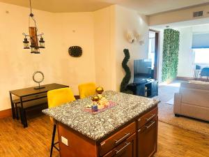 a living room with a kitchen with a table and yellow chairs at 3BR King Bed Chamber Apartment at The Grand Castle in Grandville +15 photos