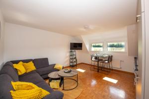 a living room with a couch and a table at Ferienwohnung Moselblick Zell-Merl - Merllorca DG Panoramablick & Parkplatz in Zell an der Mosel
