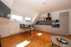 a kitchen with white cabinets and a table at Ferienwohnung Moselblick Zell-Merl - Merllorca DG Panoramablick & Parkplatz in Zell an der Mosel