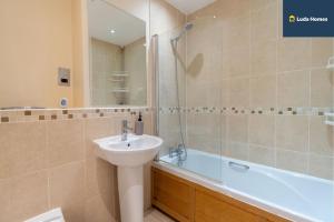 a bathroom with a sink and a toilet and a tub at Charming 2-Bed Apt - Close to amenities - Sleep 6 in Watford West Station +46 photos