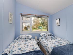 a bedroom with two beds and a window at Scarba in Balvicar