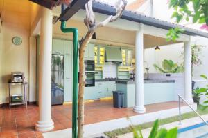 a house with a kitchen on the side of it at The Dutch Bungalow Seminyak in Seminyak