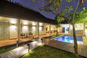 a villa with a swimming pool at night at The Dutch Bungalow Seminyak in Seminyak