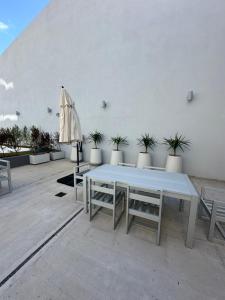 einen weißen Tisch und Stühle sowie einen Regenschirm in der Unterkunft MOVISTAR ARENA PREMIUM THAMES 56 7 piso 713 Cocheras y Seguridad in Buenos Aires