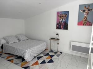 a bedroom with a bed and paintings on the wall at Gutenberg's Nest in Carcassonne