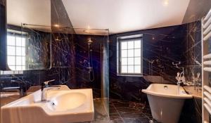 a bathroom with a sink and a tub and a toilet at Maison de ville in Saint-Pol-de-Léon