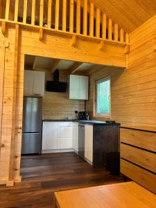 a kitchen with wooden walls and a wooden floor at EL PINO - domek w lesie in Skrzynka +4 photos