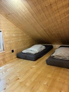 two beds in a room with a wooden ceiling at EL PINO - domek w lesie in Skrzynka