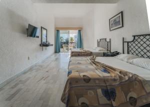 a room with two beds and a television on the wall at Imperial Las Perlas in Cancún