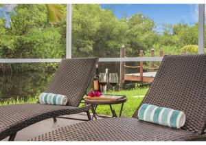 twee stoelen en een tafel met een glas wijn bij NO EXTRA FEES! Heated pool, Rods, BBQ, Fire Pite, 8 PAX, 2BR, 3BA in North Fort Myers