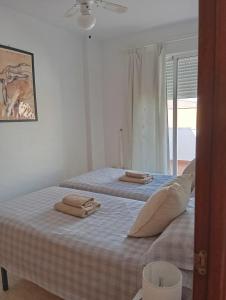une chambre avec deux lits avec des serviettes dessus dans l'établissement One-bedroom flat 200m from the beach, à Almería