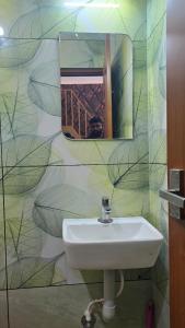 a bathroom with a sink and a mirror on a wall at Elora Homes in Vagamon