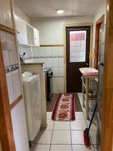 a kitchen with a washing machine and a door at Casa Cabaña Oro Rayado Puerto Varas in Puerto Varas