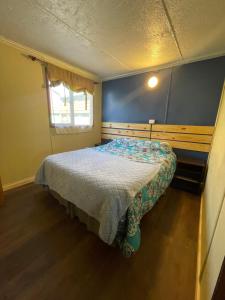 a small bedroom with a bed in a room at Casa Cabaña Oro Rayado Puerto Varas in Puerto Varas