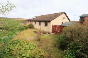 a white house with a red fence in a yard at Millbrae, Lerwick in Lerwick
