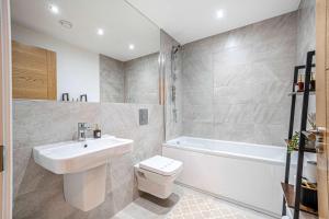 a bathroom with a sink and a toilet and a tub at Luxury 2BR Penthouse-1, Private Terrace, City Center, Free Parking in Leeds