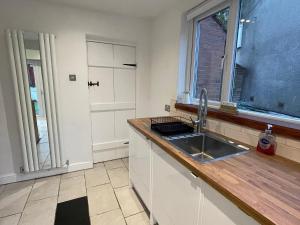 een keuken met een spoelbak en een raam bij Mallison Cottage in Stalybridge +42 foto's