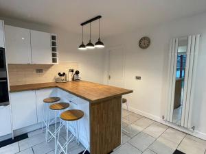 een keuken met een houten aanrecht en krukken bij Mallison Cottage in Stalybridge