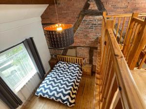 een kamer met een stoel en een trap met een kroonluchter bij Mallison Cottage in Stalybridge