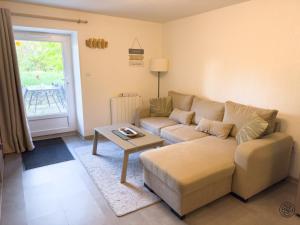 a living room with a couch and a table at Le Maé classé 4 étoiles, terrasse et parking in Dole