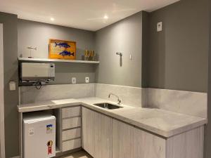 a kitchen with a sink and a counter top at Flat in 4-star hotel with panoramic pool in Cabo Frio