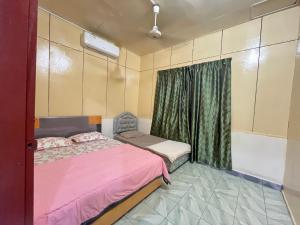 - une chambre avec un lit rose et une fenêtre dans l'établissement CSG Homestay Kota Marudu, à Kampong Sorosob
