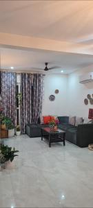 a living room with a couch and a table at Sweethome in Lāndrān +1 photo