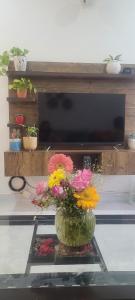 a vase filled with flowers on a glass table at Sweethome in Lāndrān