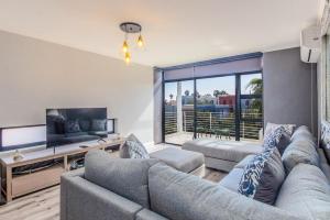 a living room with a couch and a tv at Quayside 301 by CTHA in Cape Town