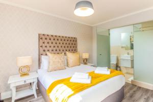 a bedroom with a large white bed and a bathroom at Quayside 301 by CTHA in Cape Town