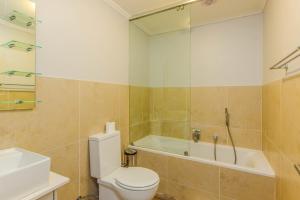 a bathroom with a toilet and a tub and a sink at Quayside 301 by CTHA in Cape Town +7 photos