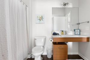 a white bathroom with a toilet and a sink at Trailside Haven @ Trailside45 in Traverse City +31 photos