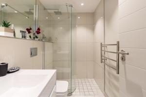 ein weißes Badezimmer mit Dusche und Waschbecken in der Unterkunft The Docklands 509 by CTHA in Kapstadt + 23 Fotos