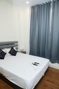 JāmbにあるHotel Freedom Internationalのベッドルーム(青いカーテン付きの白いベッド1台付)