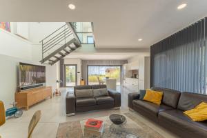 a living room with a couch and a tv at Albaé - Climatisé - Piscine - Parking - Provence in Allauch