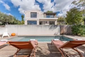 a swimming pool with two chairs and a house at Albaé - Climatisé - Piscine - Parking - Provence in Allauch