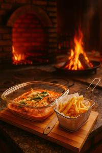 a table with a dish of food and a bowl of fries at Pousada Vison in Itapeva
