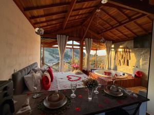 a dining room with a table and a bath tub at Pousada da Cachoeira - Chalé pôr do sol in Camanducaia