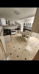 a kitchen with a table and chairs on a tiled floor at Casa da viçosa in Viçosa do Ceará