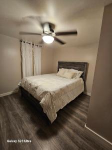 a bedroom with a bed with a ceiling fan at Reel Relaxin Retreat to Getaway! in Houghton Lake