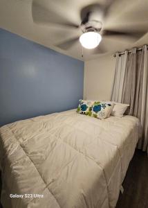 a bedroom with a bed with a ceiling fan at Reel Relaxin Retreat to Getaway! in Houghton Lake